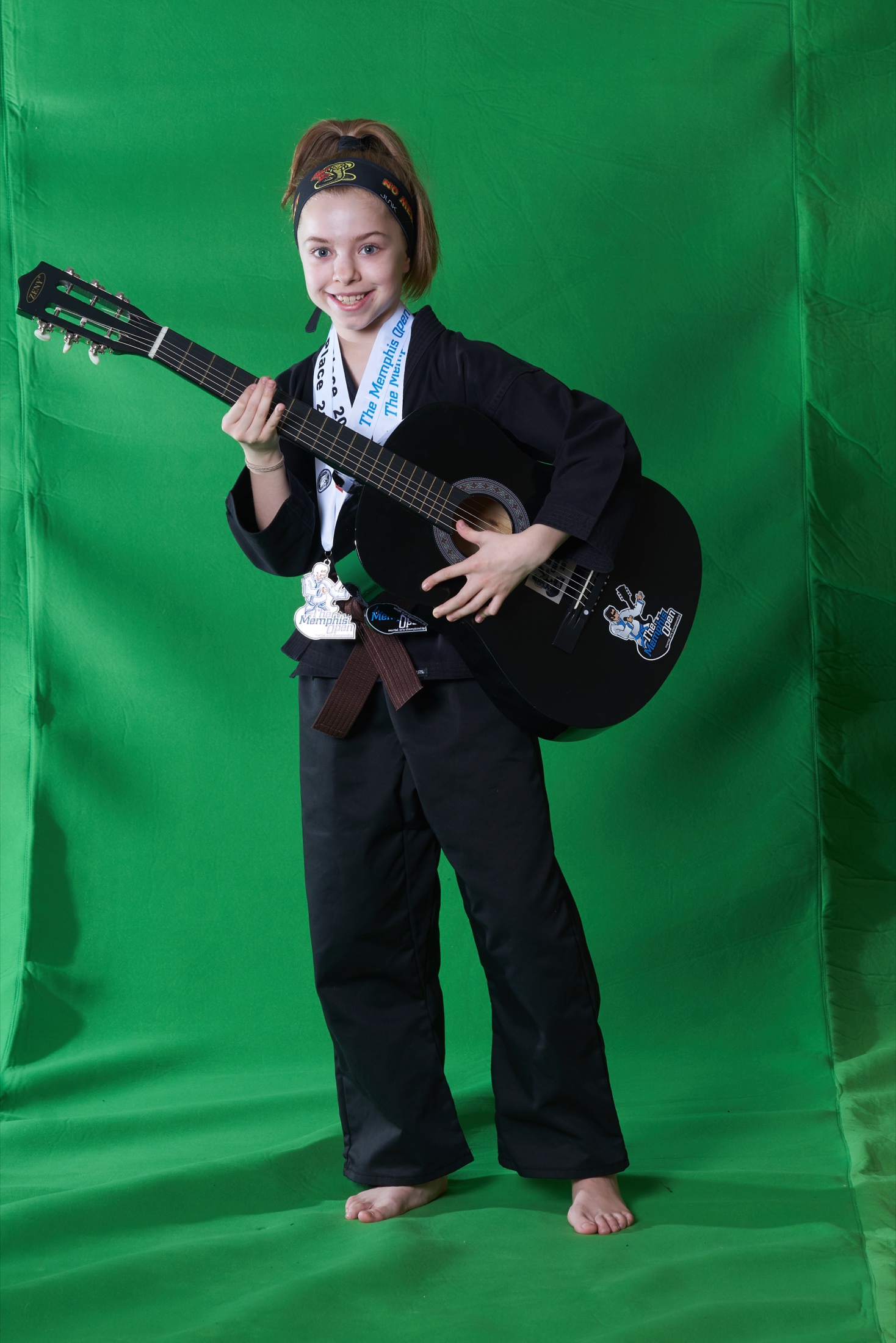 Young Memphis Open champion holding the signature guitar award